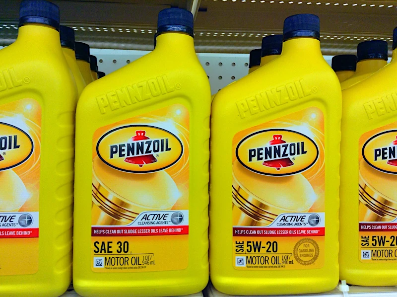 Bottles of Pennzoil motor oil on a store shelf.